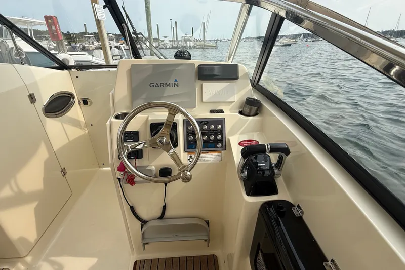 Slide: The Image of 2018 Scout 275 Dorado boat cockpit with Garmin navigation system, steering wheel, and throttle controls. - 14