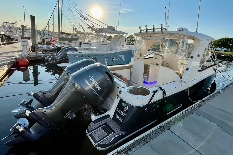 Slide: The Image of 2018 Scout 275 Dorado boat docked with Yamaha engines, sun setting in the background. - 1