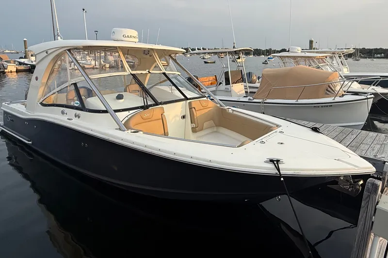 Slide: The Image of 2018 Scout 275 Dorado boat docked at marina, featuring sleek design and spacious seating. - 2