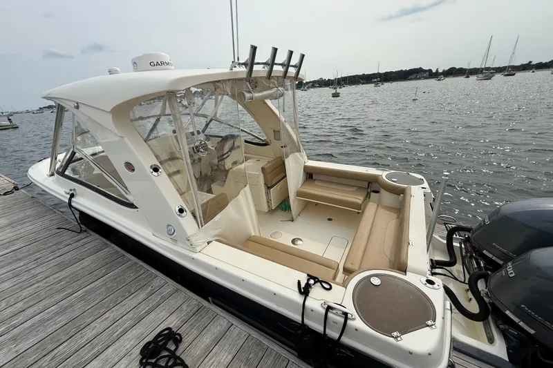 Slide: The Image of 2018 Scout 275 Dorado boat docked, featuring spacious seating and twin engines. - 5