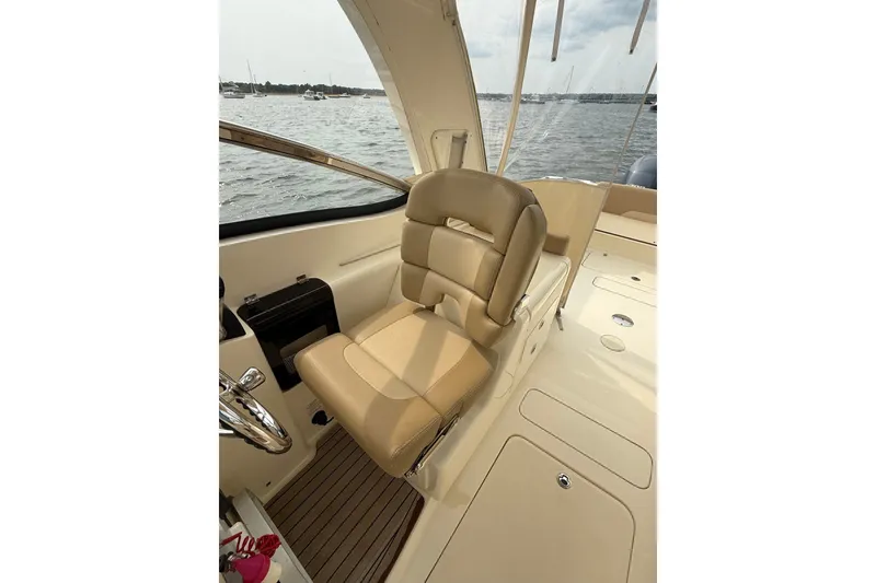 Slide: The Image of 2018 Scout 275 Dorado boat interior with beige seating and water view. - 18