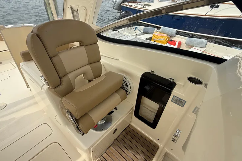 Slide: The Image of Captain's chair on 2018 Scout 275 Dorado boat, featuring beige upholstery and sleek design. - 19