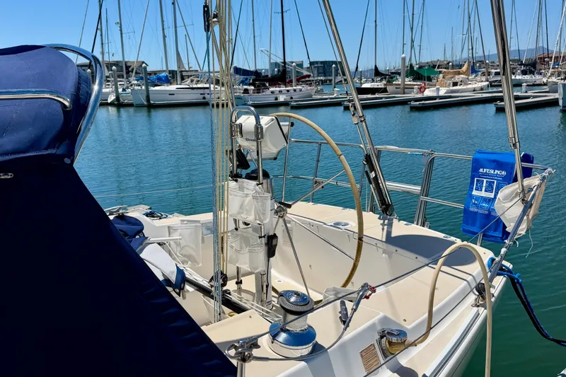 Slide: The Image of 2001 J Boats J/32 sailboat cockpit in marina, featuring steering wheel and safety equipment. - 48