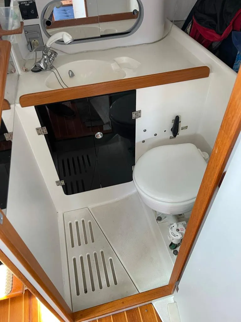 Slide: The Image of The image shows a boat bathroom with a sink, toilet, and wooden accents. - 37