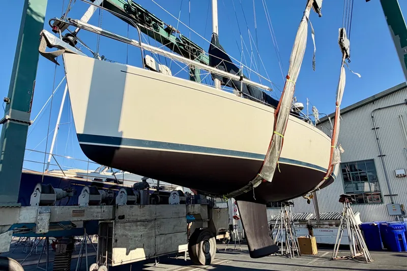 Slide: The Image of 2001 J Boats J/32 sailboat suspended in a boatyard lift for maintenance. - 43