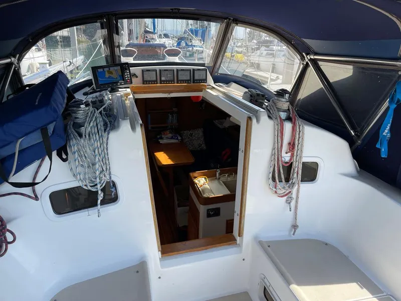 Slide: The Image of The cockpit of a 2001 J/32 with navigation system and ropes. The cabin entrance is visible. - 15