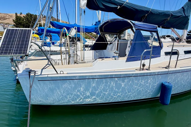 Slide: The Image of 2001 J Boats J/32 sailboat docked with solar panel and blue canopy. - 49