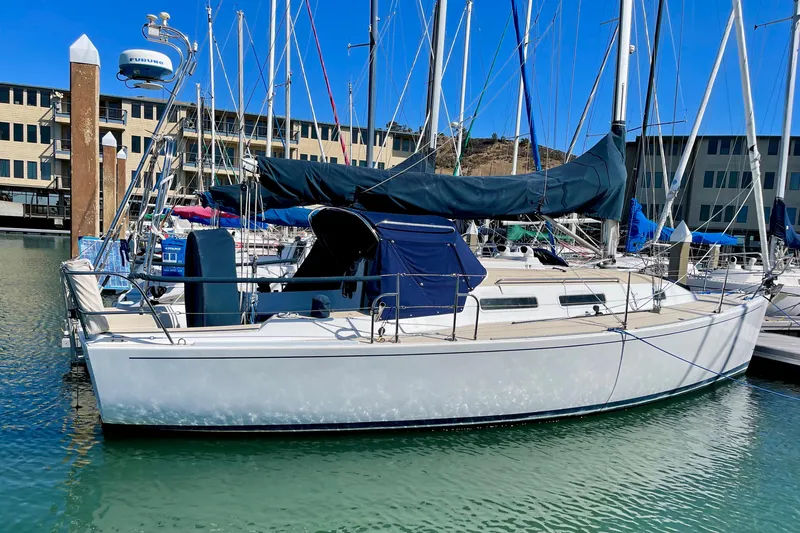 Slide: The Image of A white sailboat docked in a marina, featuring a blue sail and spacious cabin. - 3