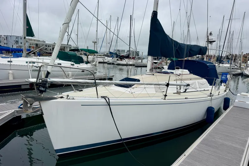 Slide: The Image of 2001 J Boats J/32 sailboat docked in a marina, surrounded by other vessels. - 4