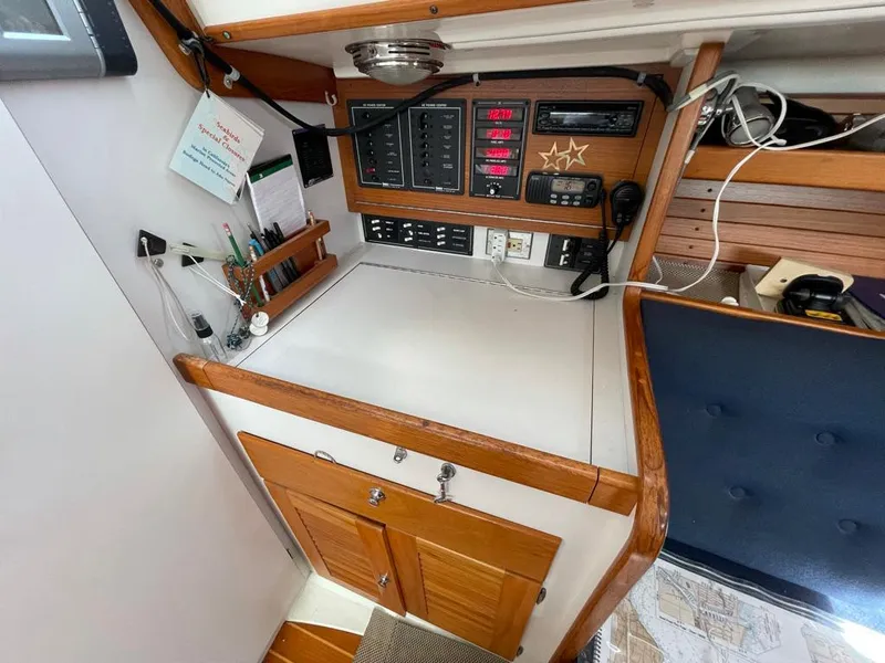 Slide: The Image of The navigation area of a 2001 J/32 with wood paneling and electronic instruments. - 26