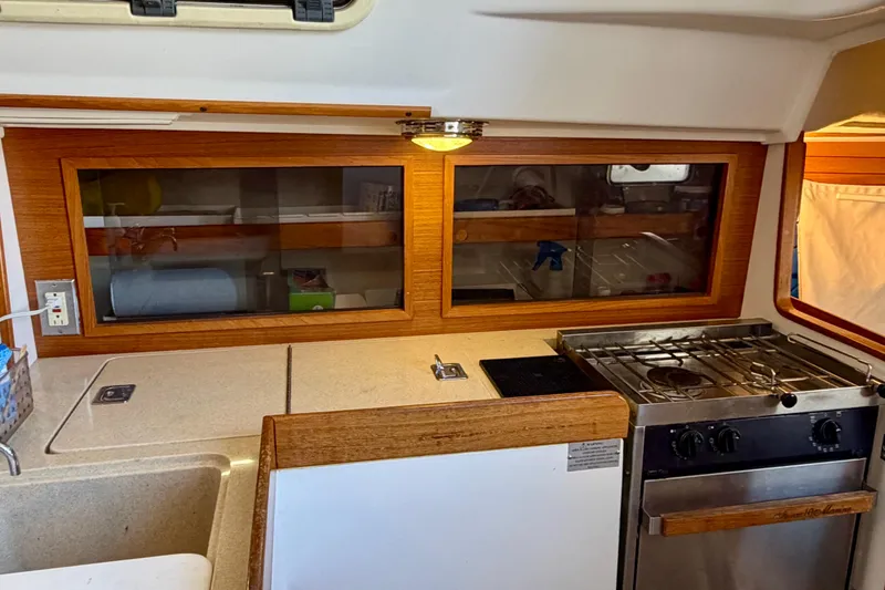 Slide: The Image of Interior of a 2001 J Boats J/32 sailboat featuring a compact kitchen with stove and sink. - 18