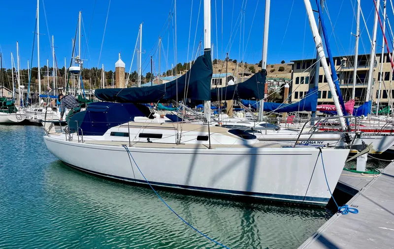 Slide: The Image of A white sailboat docked in a marina, surrounded by other boats and buildings in the background. - 2