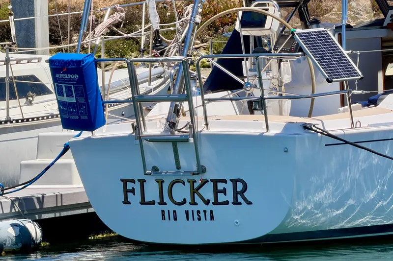 Slide: The Image of 2001 J Boats J/32 sailboat "Flicker" docked, featuring solar panel and lifesaving equipment. - 7