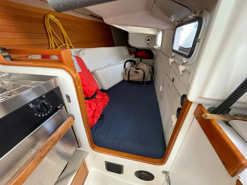 Slide: The Image of Interior view of a 2001 J/32 with sleeping area, luggage, and safety gear. - 28
