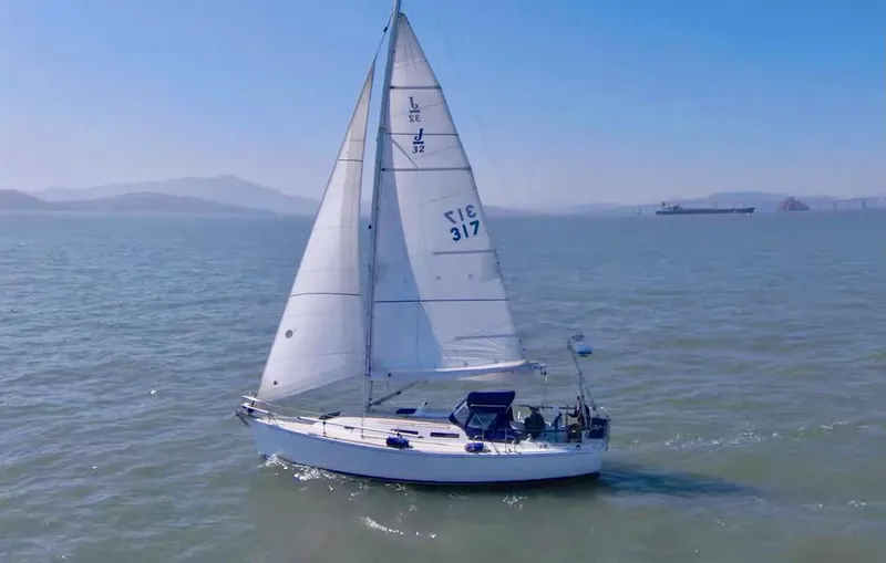 Slide: The Image of A white sailboat glides on calm waters under a clear sky. The sails are fully unfurled. - 1