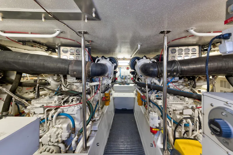 Slide: The Image of Engine room of 2003 Hatteras 60 Convertible yacht, showcasing dual engines and complex piping. - 41