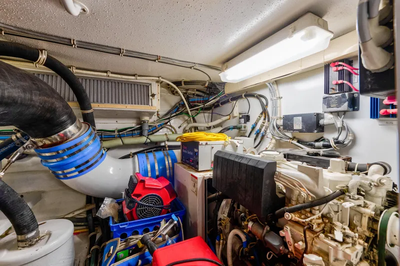 Slide: The Image of Engine room of a 2003 Hatteras 60 Convertible yacht, showcasing machinery and wiring. - 46