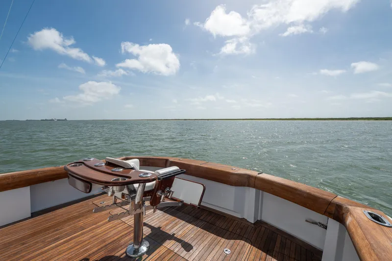 Slide: The Image of Deck view of 2003 Hatteras 60 Convertible yacht on open water under blue sky. - 16