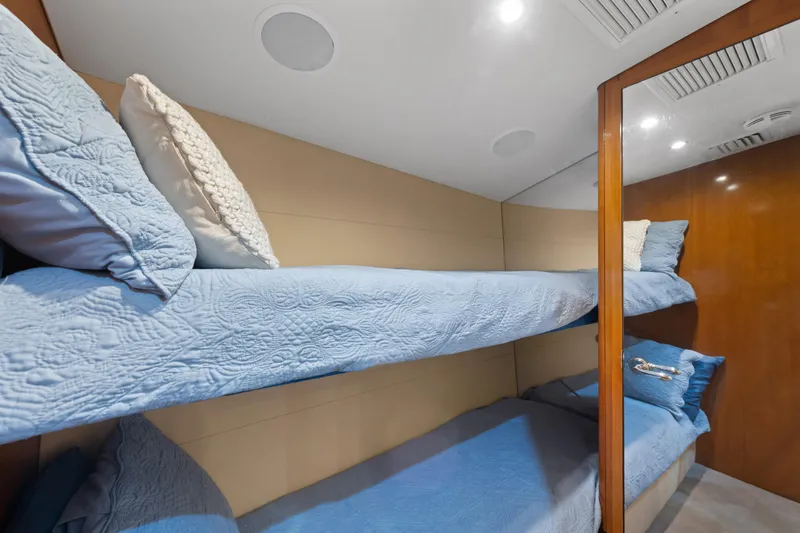 Slide: The Image of Bunk beds with blue bedding in a 2003 Hatteras 60 Convertible yacht cabin. - 34