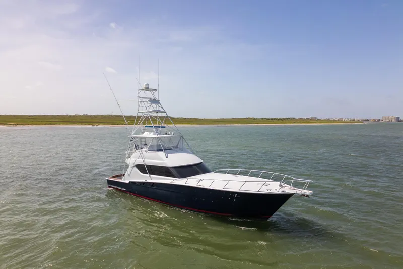 The Image of 2003 Hatteras 60 Convertible yacht cruising on open water under clear skies. - 1