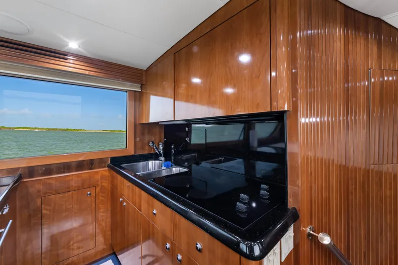 Slide: The Image of Luxurious kitchen interior of 2003 Hatteras 60 Convertible yacht with wood cabinetry and ocean view. - 27
