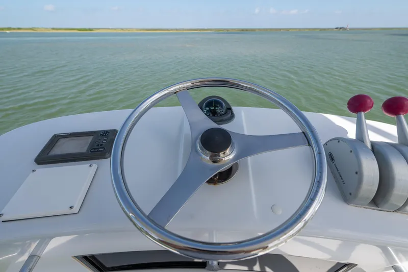 Slide: The Image of Helm of 2003 Hatteras 60 Convertible yacht with steering wheel and controls. - 12
