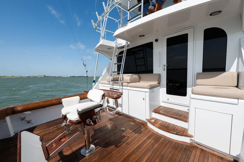 Slide: The Image of 2003 Hatteras 60 Convertible yacht deck with seating and fishing chair, overlooking the ocean. - 14