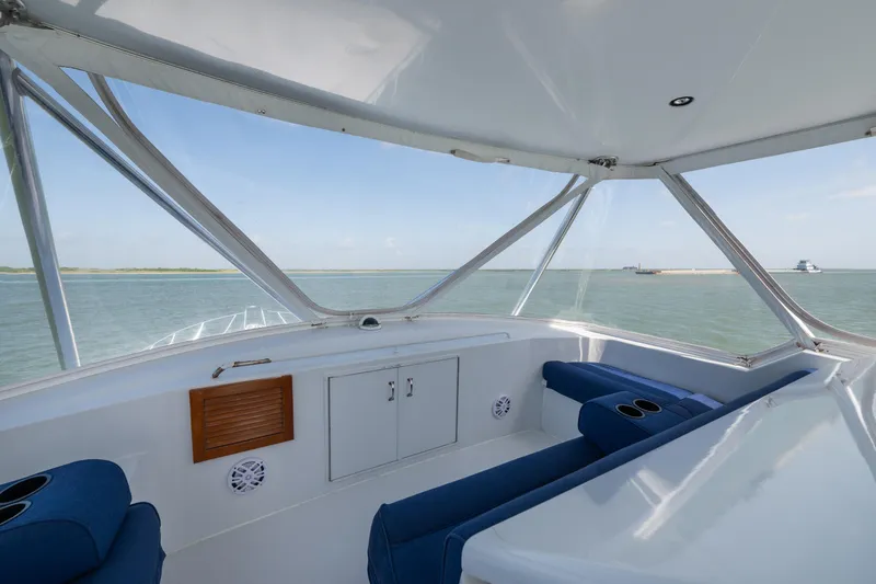 Slide: The Image of Interior view of 2003 Hatteras 60 Convertible yacht with blue seating and ocean backdrop. - 10