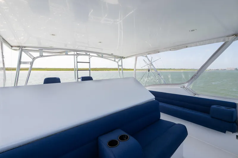Slide: The Image of Spacious deck of 2003 Hatteras 60 Convertible yacht with blue seating and ocean view. - 8