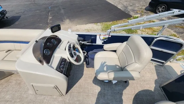 Slide: The Image of The image shows the cockpit of a 2017 Berkshire 17CL 2.0 pontoon boat with a beige captain's chair and a helm with instruments. - 10