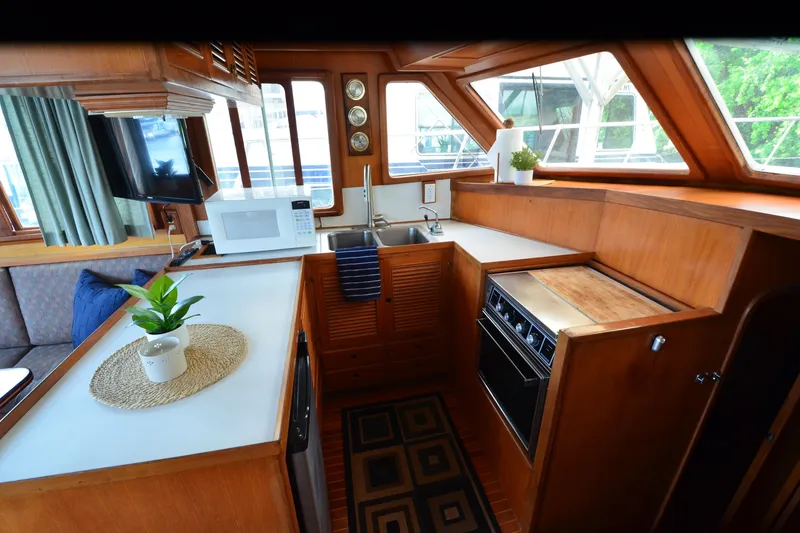 Slide: The Image of Interior of 1985 Kha Shing 40 yacht kitchen with wood finish, microwave, and sink. - 30