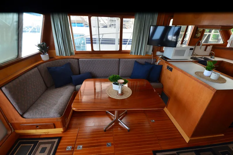 Slide: The Image of Interior of 1985 Kha Shing 40 yacht with cozy seating, table, and kitchenette. - 26