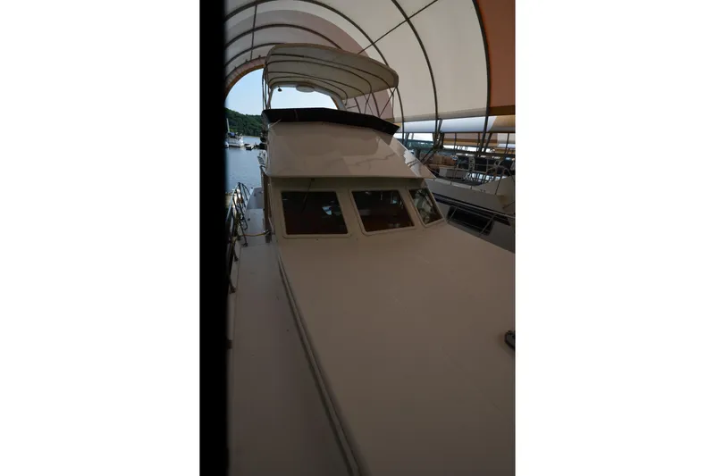 Slide: The Image of 1985 Kha Shing 40 yacht under a canopy, docked at a marina. - 23