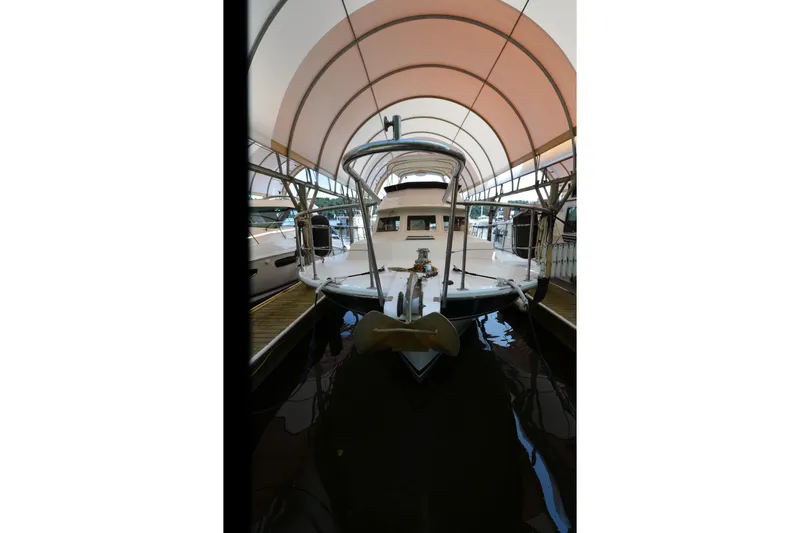 Slide: The Image of 1985 Kha Shing 40 yacht docked under a canopy, front view. - 41