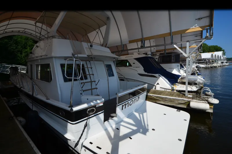 Slide: The Image of 1985 Kha Shing 40 yacht docked under canopy, named "Mona," at a marina. - 5