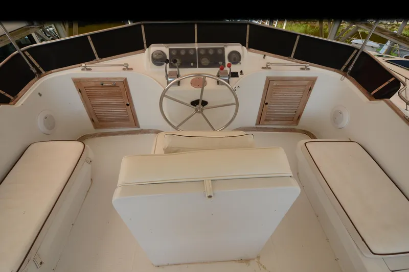 Slide: The Image of 1985 Kha Shing 40 boat helm with steering wheel and cushioned seating. - 13