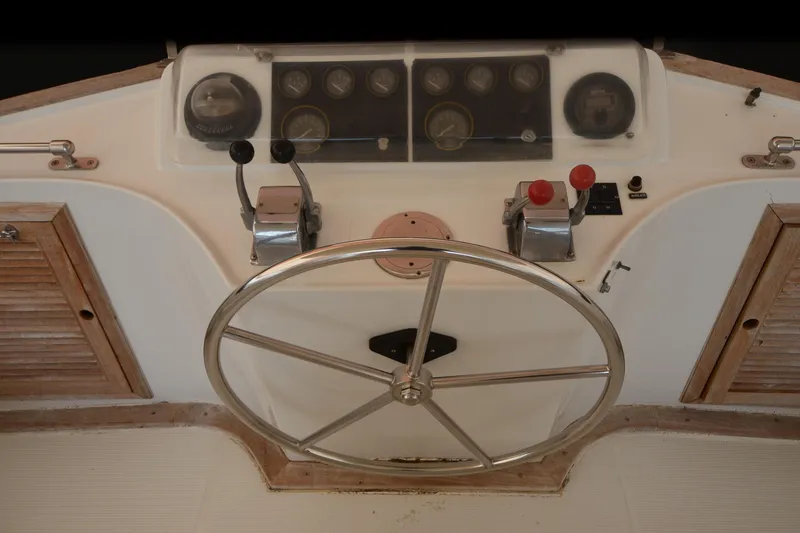 Slide: The Image of Steering wheel and controls of a 1985 Kha Shing 40 boat cockpit. - 14