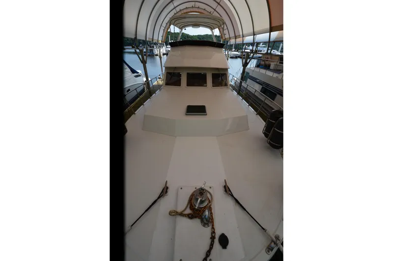 Slide: The Image of 1985 Kha Shing 40 yacht docked under canopy, showcasing spacious deck and sleek design. - 21
