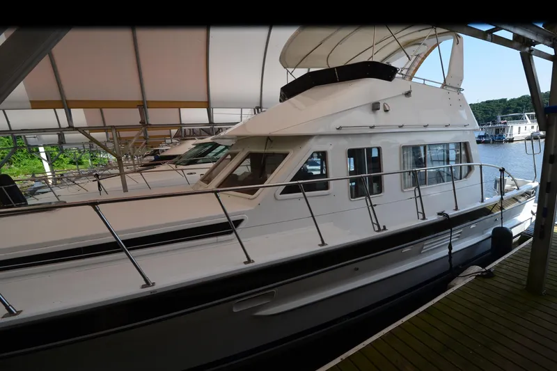 Slide: The Image of 1985 Kha Shing 40 yacht docked under a canopy, side view. - 7
