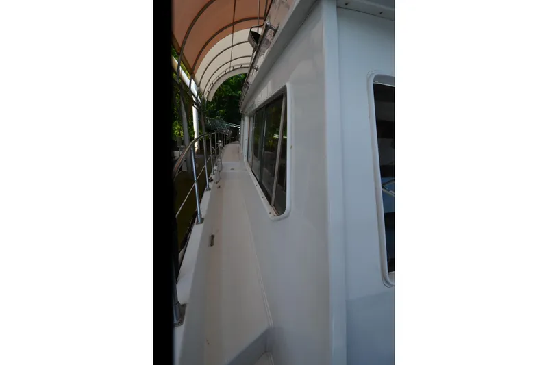 Slide: The Image of Side view of a 1985 Kha Shing 40 yacht under a canopy. - 17