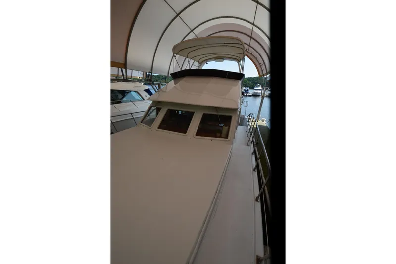 Slide: The Image of 1985 Kha Shing 40 yacht under a canopy at a marina. - 24