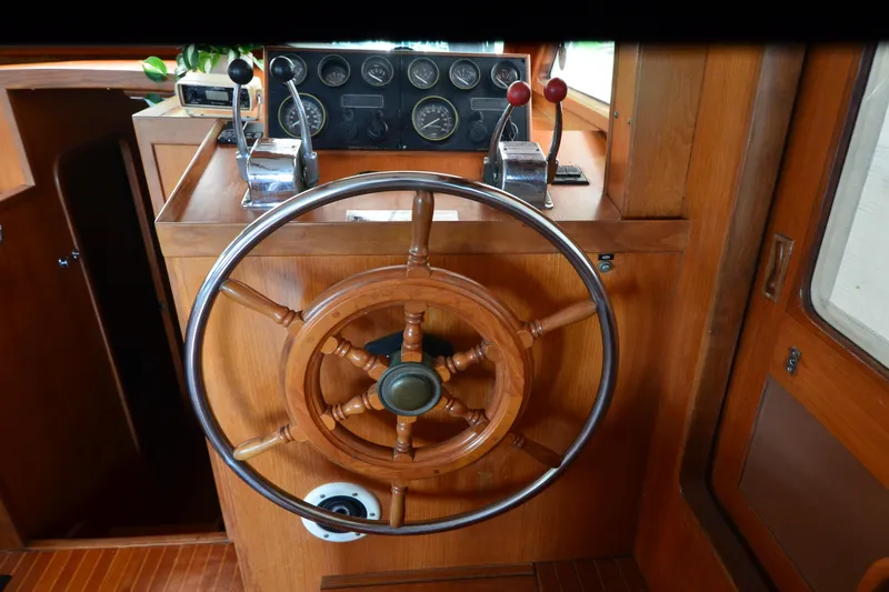 Slide: The Image of Wooden helm of a 1985 Kha Shing 40 yacht with control panel and levers. - 28