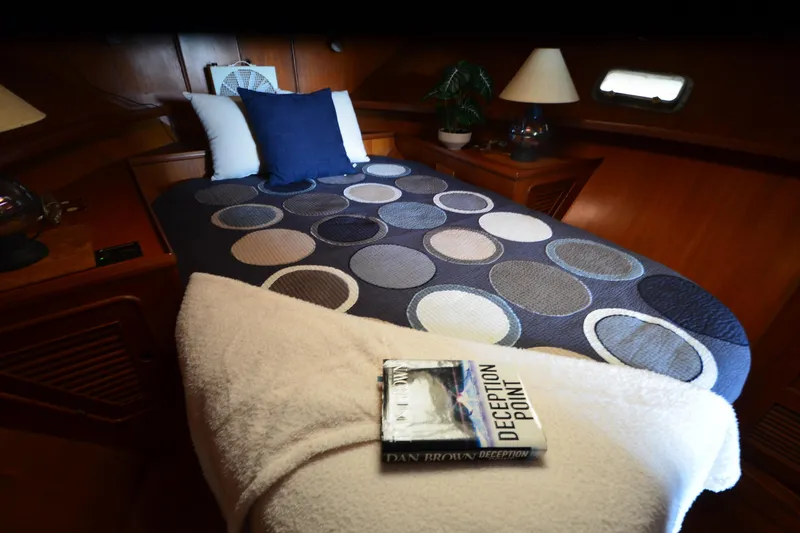 Slide: The Image of Cozy cabin interior of 1985 Kha Shing 40 yacht with patterned bedding and book. - 34