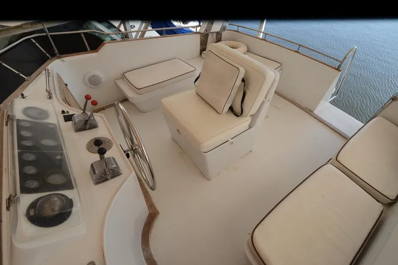 Slide: The Image of 1985 Kha Shing 40 yacht helm with white seating and control panel. - 16