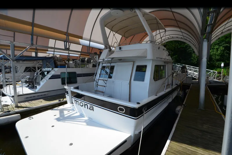 Slide: The Image of 1985 Kha Shing 40 yacht docked under canopy, featuring sleek design and spacious deck. - 3