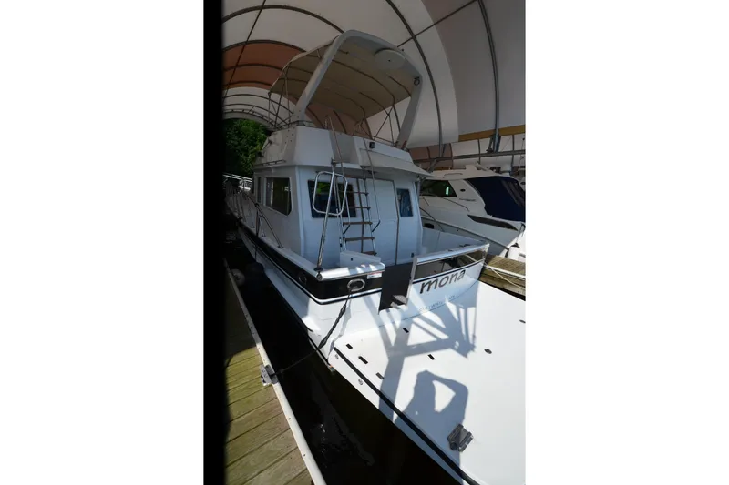 Slide: The Image of 1985 Kha Shing 40 yacht docked under a canopy, showcasing its sleek design. - 4