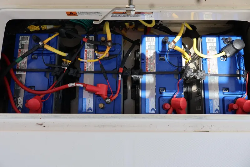 Slide: The Image of 2018 Robalo R302 Center Console boat battery compartment with multiple blue batteries. - 16