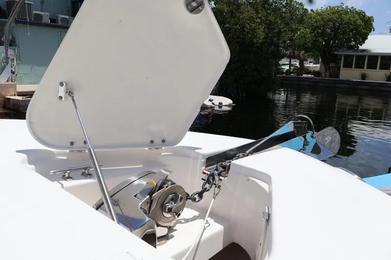Slide: The Image of 2018 Robalo R302 Center Console anchor compartment with open hatch, docked near water. - 8