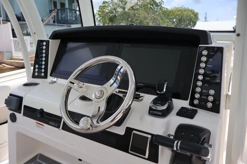Slide: The Image of 2018 Robalo R302 Center Console helm with dual displays and modern controls. - 10