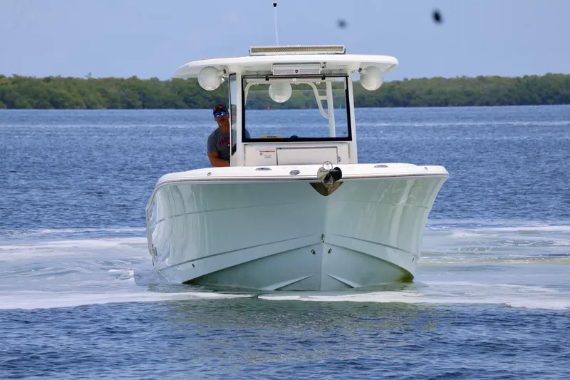 Slide: The Image of 2018 Robalo R302 Center Console boat cruising on calm waters. - 4